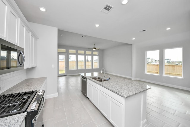 kitchen featuring recessed lighting, a sink, visible vents, open floor plan, and appliances with stainless steel finishes