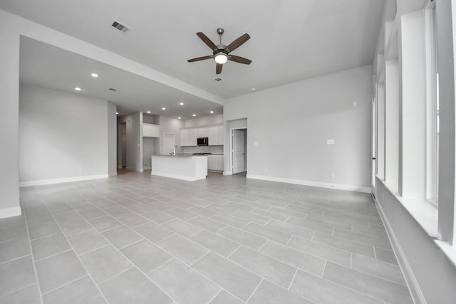 unfurnished living room featuring visible vents, baseboards, ceiling fan, a sink, and recessed lighting