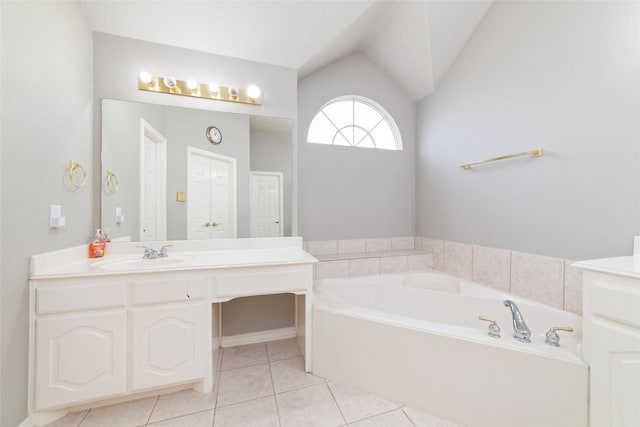 bathroom with a washtub, vanity, vaulted ceiling, and tile patterned flooring