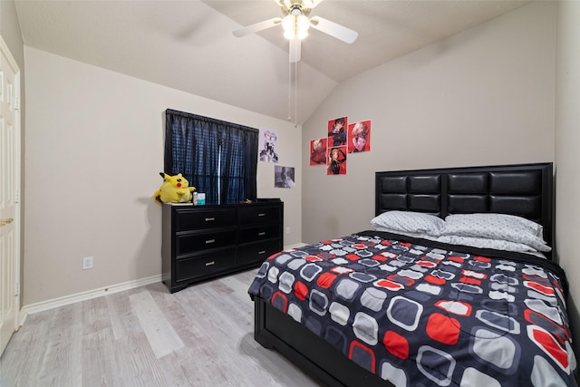 bedroom with ceiling fan, vaulted ceiling, and light wood-type flooring