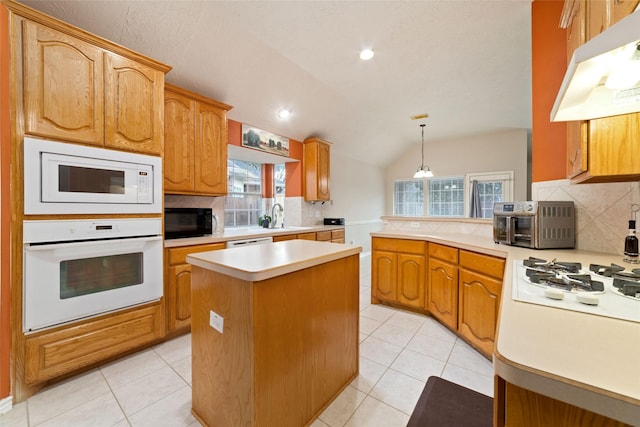 kitchen featuring sink, hanging light fixtures, lofted ceiling, white appliances, and a kitchen island