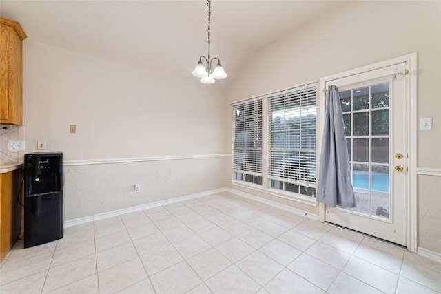 unfurnished dining area with light tile patterned flooring, lofted ceiling, and an inviting chandelier