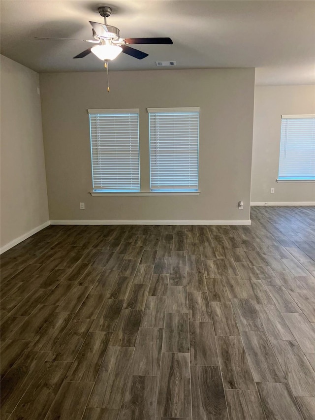 spare room featuring ceiling fan and dark wood-type flooring