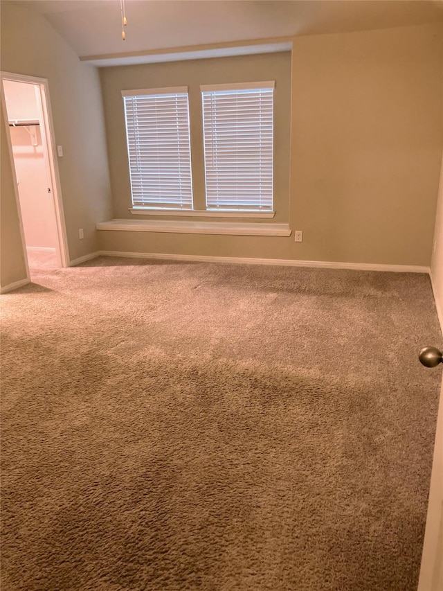 empty room with carpet and lofted ceiling