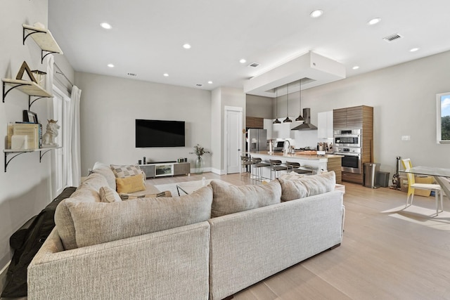 living room with sink and light hardwood / wood-style floors