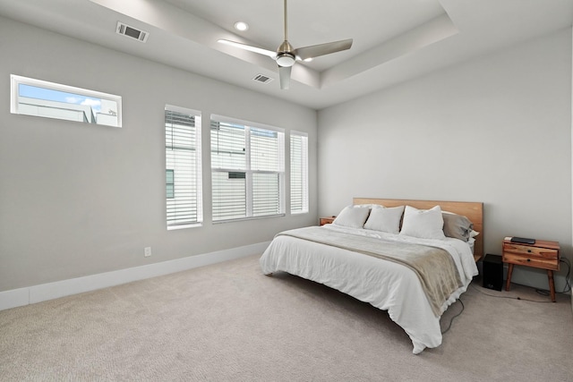 bedroom featuring carpet, ceiling fan, and a tray ceiling