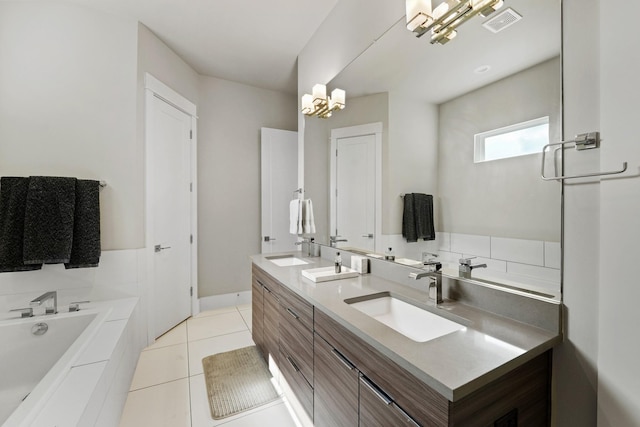 bathroom featuring tile patterned floors, vanity, tiled bath, and a chandelier