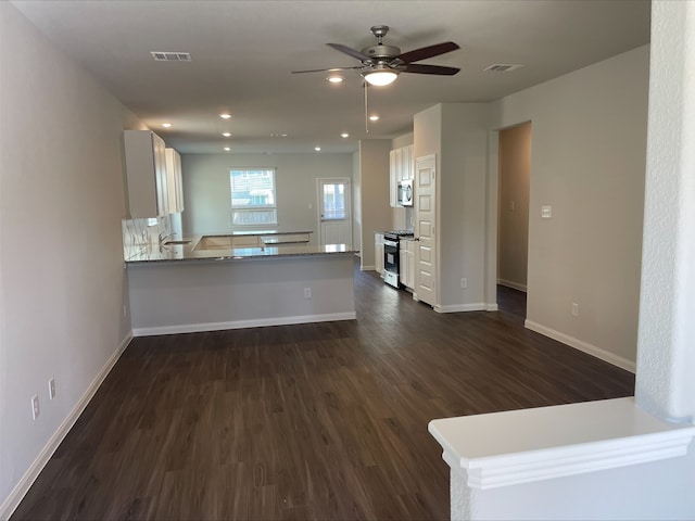 kitchen featuring sink, dark hardwood / wood-style floors, kitchen peninsula, white cabinets, and appliances with stainless steel finishes