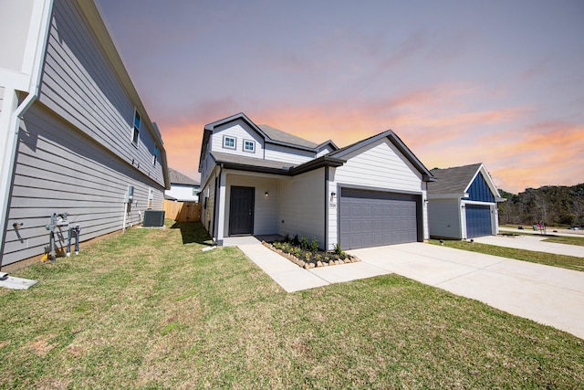 view of front of house featuring a front yard, concrete driveway, an attached garage, and fence