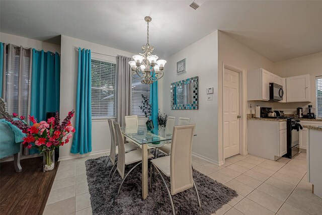 dining space with a notable chandelier and light tile patterned floors