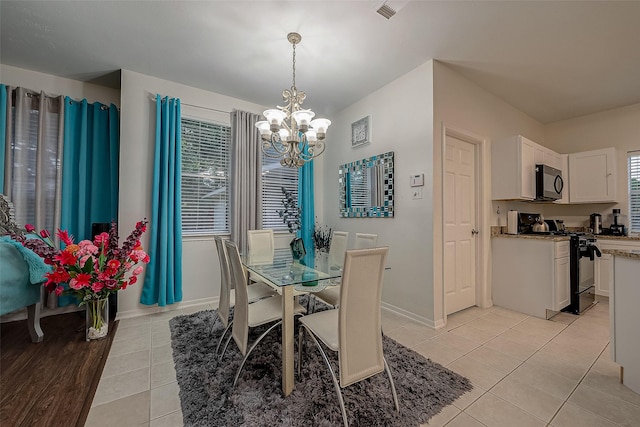 dining area with an inviting chandelier, a wealth of natural light, and light tile patterned floors