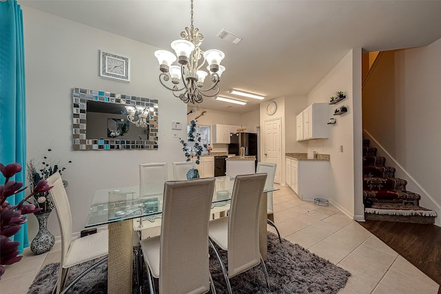 dining space with light tile patterned flooring and a chandelier