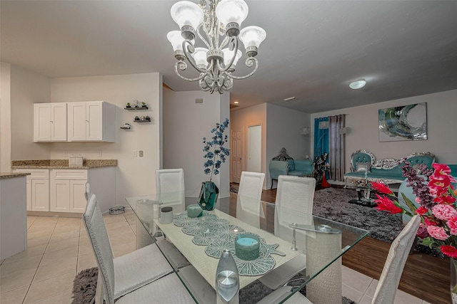 dining area with a chandelier and light tile patterned flooring