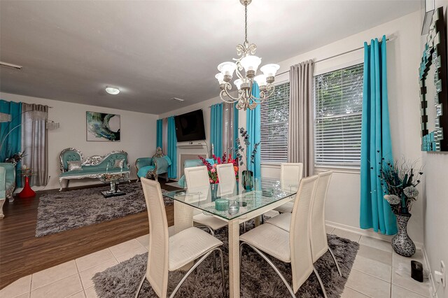 tiled dining space with an inviting chandelier