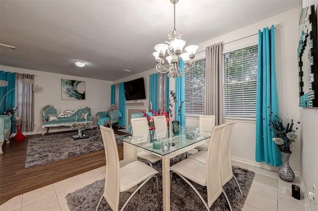 tiled dining room featuring a chandelier