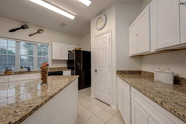 kitchen with black appliances, light stone counters, white cabinetry, and sink