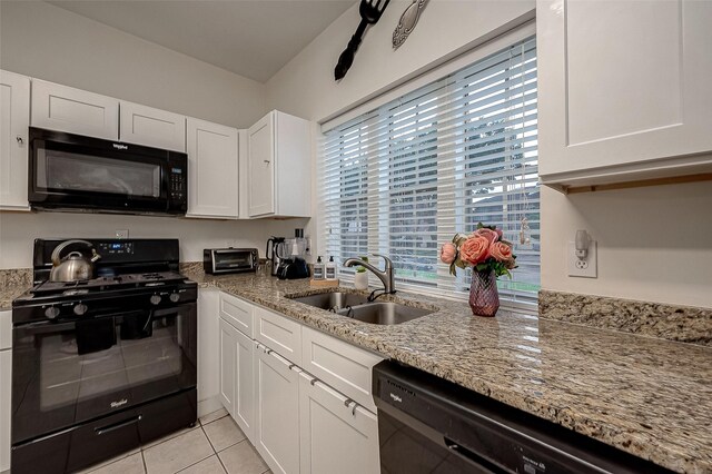 kitchen with black appliances, white cabinets, light stone countertops, and sink