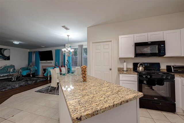 kitchen featuring a chandelier, white cabinetry, a center island, and black appliances