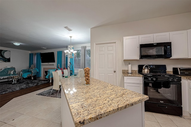 kitchen featuring white cabinetry, light tile patterned flooring, a kitchen island, and black appliances