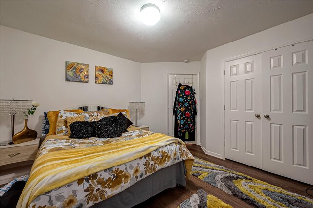 bedroom featuring a closet, dark wood-type flooring, and a textured ceiling