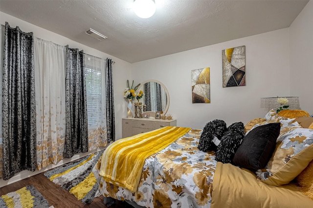 bedroom with hardwood / wood-style floors and a textured ceiling