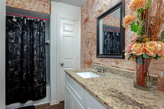 bathroom with vanity, hardwood / wood-style flooring, and shower / bath combo with shower curtain