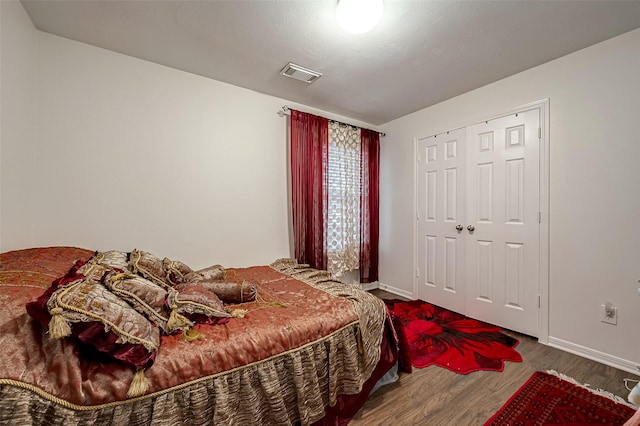 bedroom with hardwood / wood-style floors and a closet