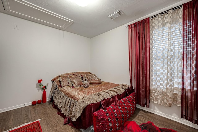 bedroom with hardwood / wood-style floors and a textured ceiling