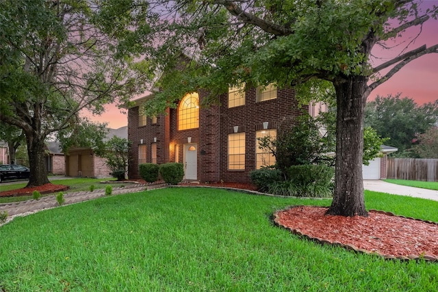 colonial-style house with a yard and a garage