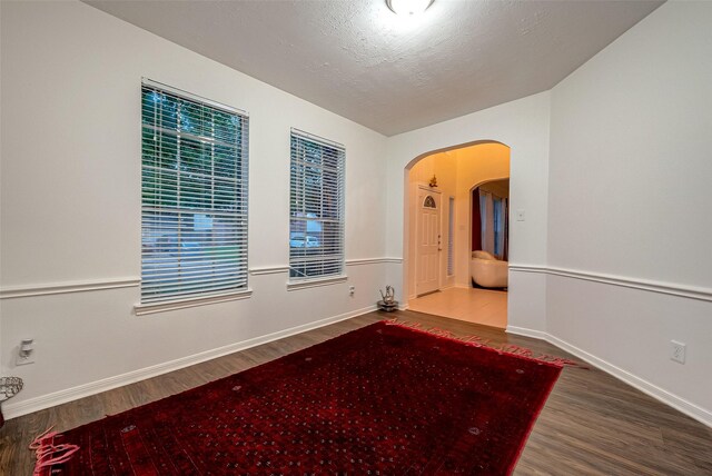 empty room featuring a textured ceiling and hardwood / wood-style flooring