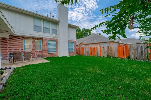 rear view of house with a lawn and a patio