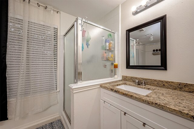 bathroom featuring vanity and tiled shower