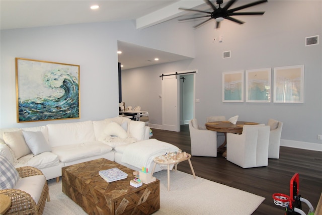 living room featuring vaulted ceiling with beams, a barn door, ceiling fan, and dark wood-type flooring