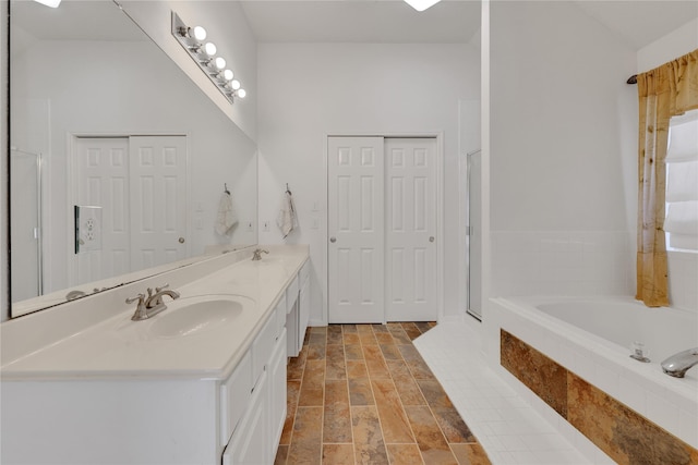 bathroom with vanity and a relaxing tiled tub