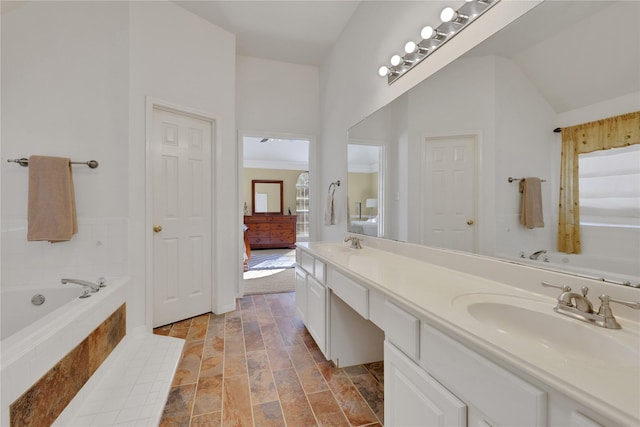 bathroom featuring vanity and a relaxing tiled tub