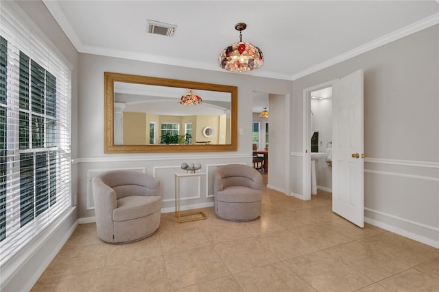 sitting room featuring light tile patterned floors, crown molding, and a wealth of natural light