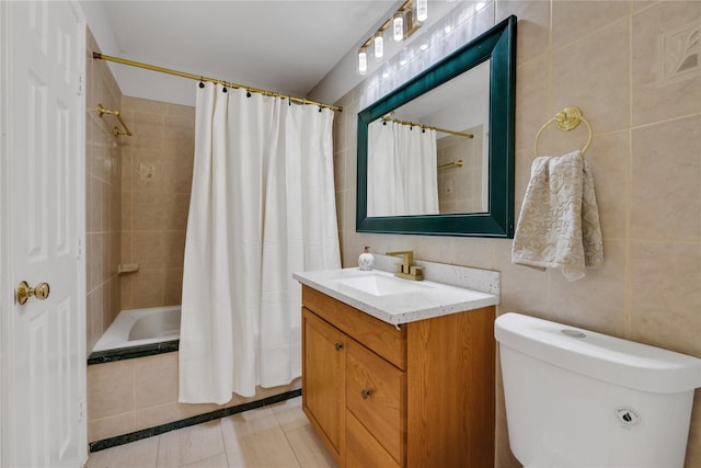 full bathroom with vanity, shower / tub combo with curtain, tile walls, tile patterned flooring, and toilet