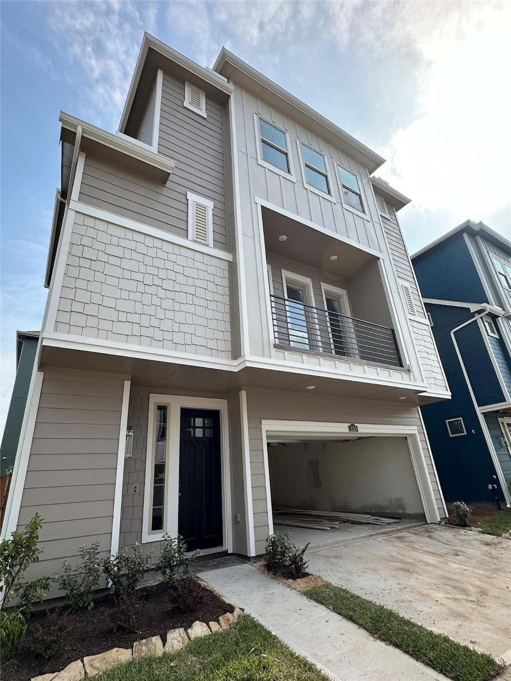 2020 Windsor Meadow Trce, Houston, TX 77051 - townhome / multi-family property featuring driveway, an attached garage, board and batten siding, and a balcony