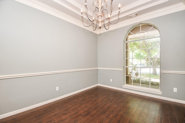 unfurnished room with a raised ceiling, dark hardwood / wood-style flooring, an inviting chandelier, and ornamental molding