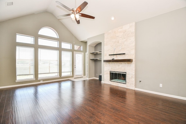 unfurnished living room with hardwood / wood-style flooring, built in features, and a stone fireplace