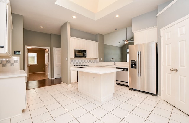 kitchen featuring a center island, sink, decorative backsplash, appliances with stainless steel finishes, and white cabinetry