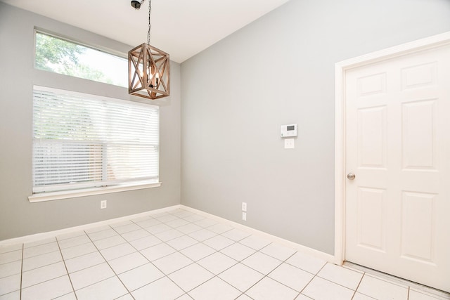 tiled empty room with a chandelier