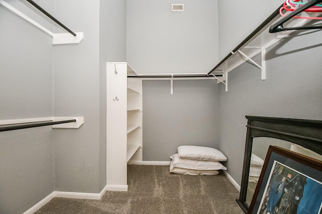 walk in closet featuring dark carpet