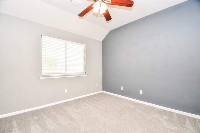 spare room featuring carpet flooring, vaulted ceiling, and ceiling fan