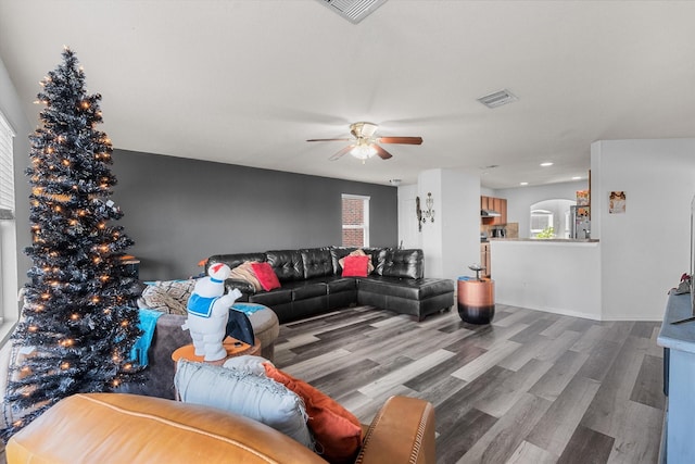 living room featuring ceiling fan, plenty of natural light, and wood-type flooring