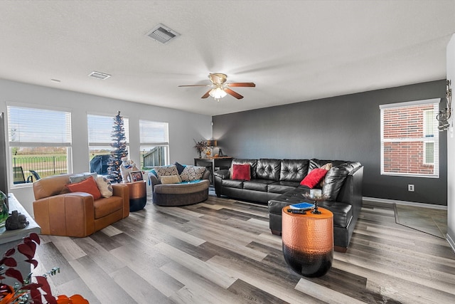 living room with light hardwood / wood-style flooring and ceiling fan