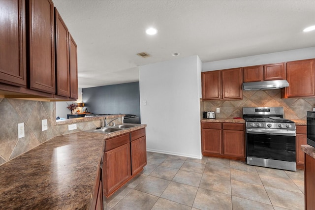 kitchen featuring light tile patterned flooring, backsplash, sink, gas stove, and kitchen peninsula