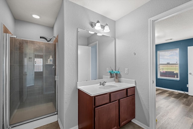 bathroom with hardwood / wood-style flooring, vanity, and a shower with shower door