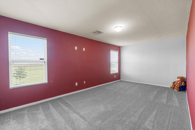 unfurnished room featuring carpet and a textured ceiling