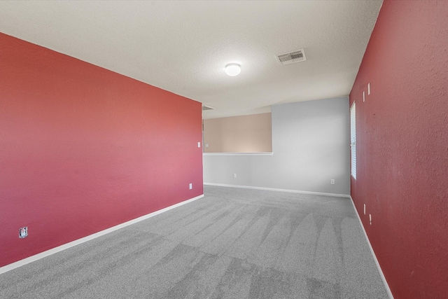 unfurnished room with carpet flooring and a textured ceiling